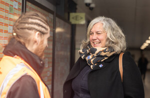 Railway worker with his back to camera talking to Transport Secretary Heidi Alexander who is facing him